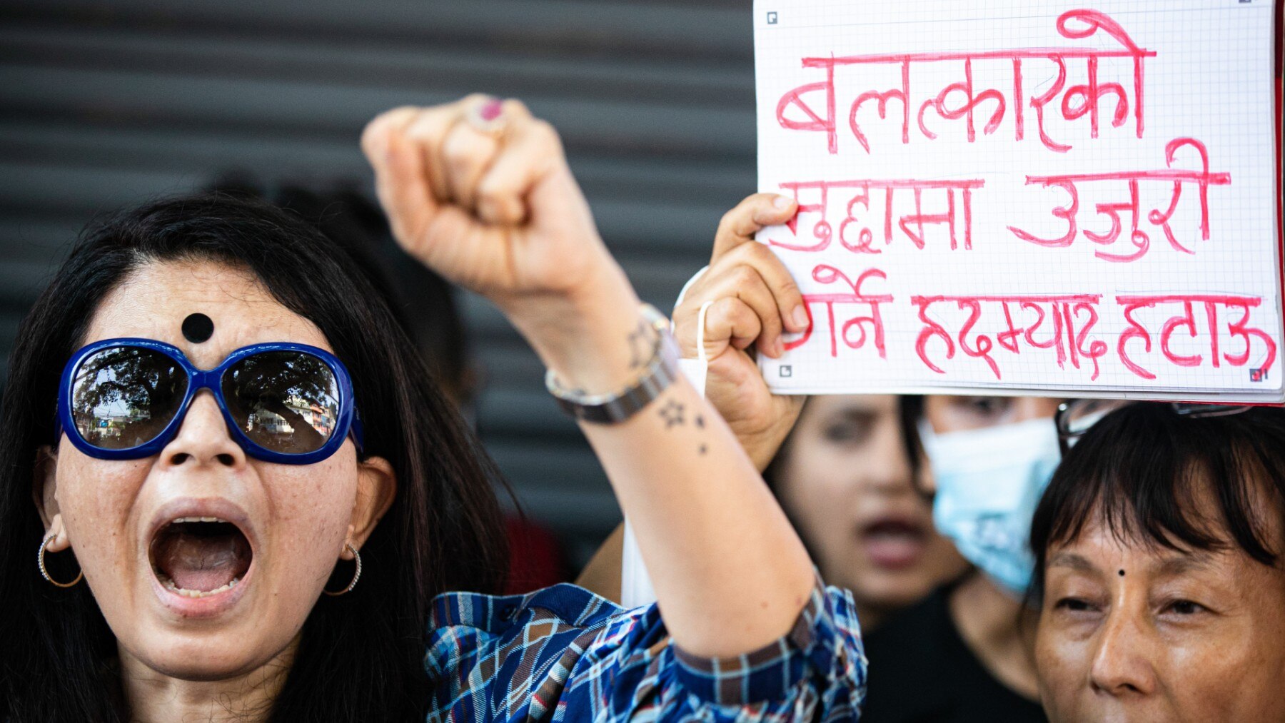 Women chant slogans while making a gesture during the demonstration near the prime minister's residence in Kathmandu. 