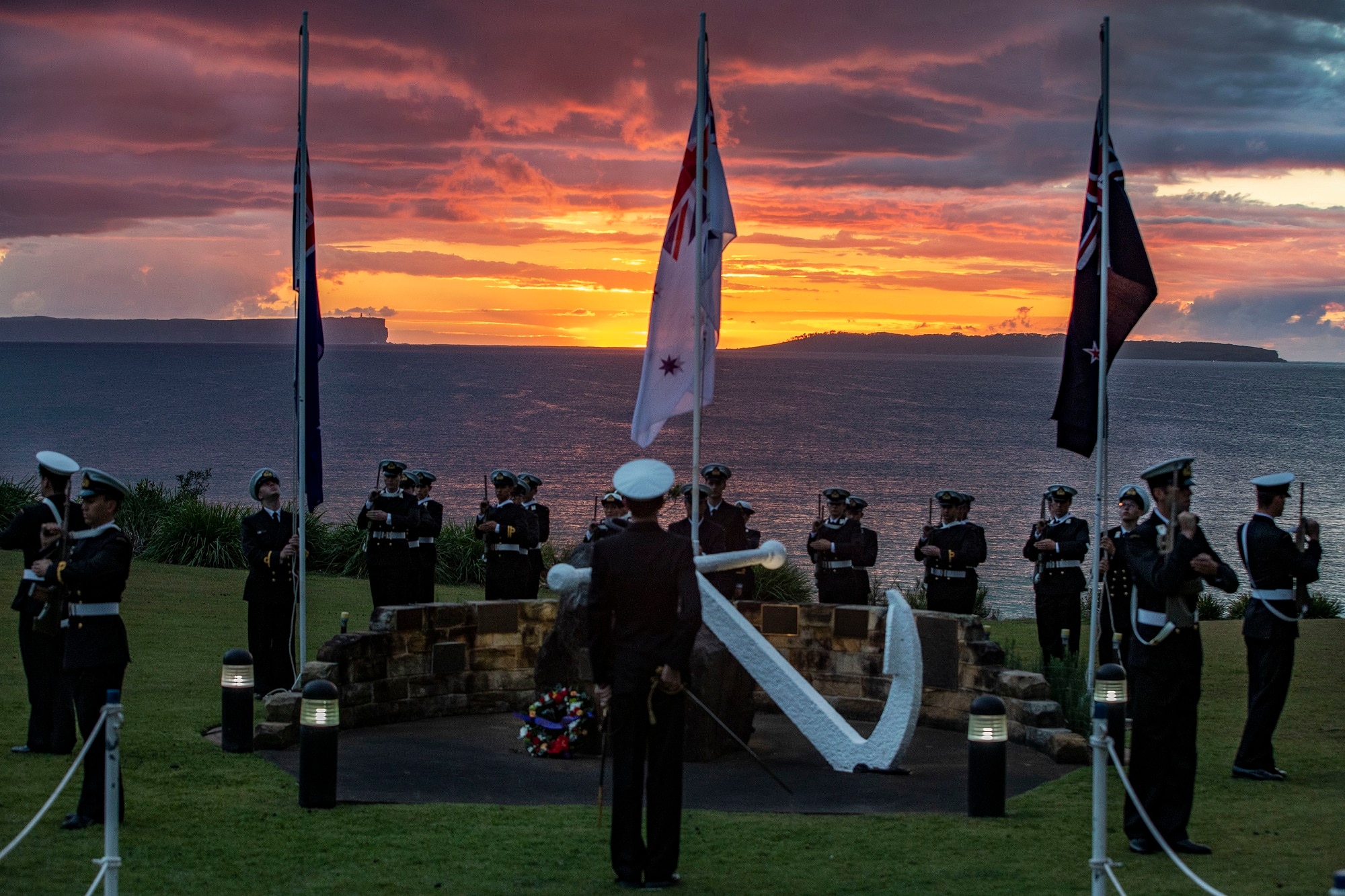 The sun rises over Point Perpendicular during the Anzac Day dawn service at HMAS Creswell, Jervis Bay in NSW.