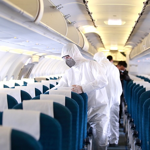 Workers prepare to spray disinfectant as a precaution against the coronavirus, inside a Vietnam Airlines airplane in Hanoi, Vietnam 3 March 2020. 