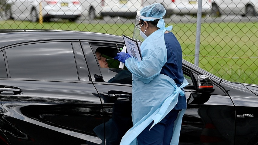 Healthcare workers administer COVID-19 tests at a drive through test centre in Liverpool, Sydney.