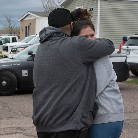 Family and friends of seven people who died in a shooting comfort each other down the street from the scene in Colorado Springs, Colorado on 9 May, 2021. 