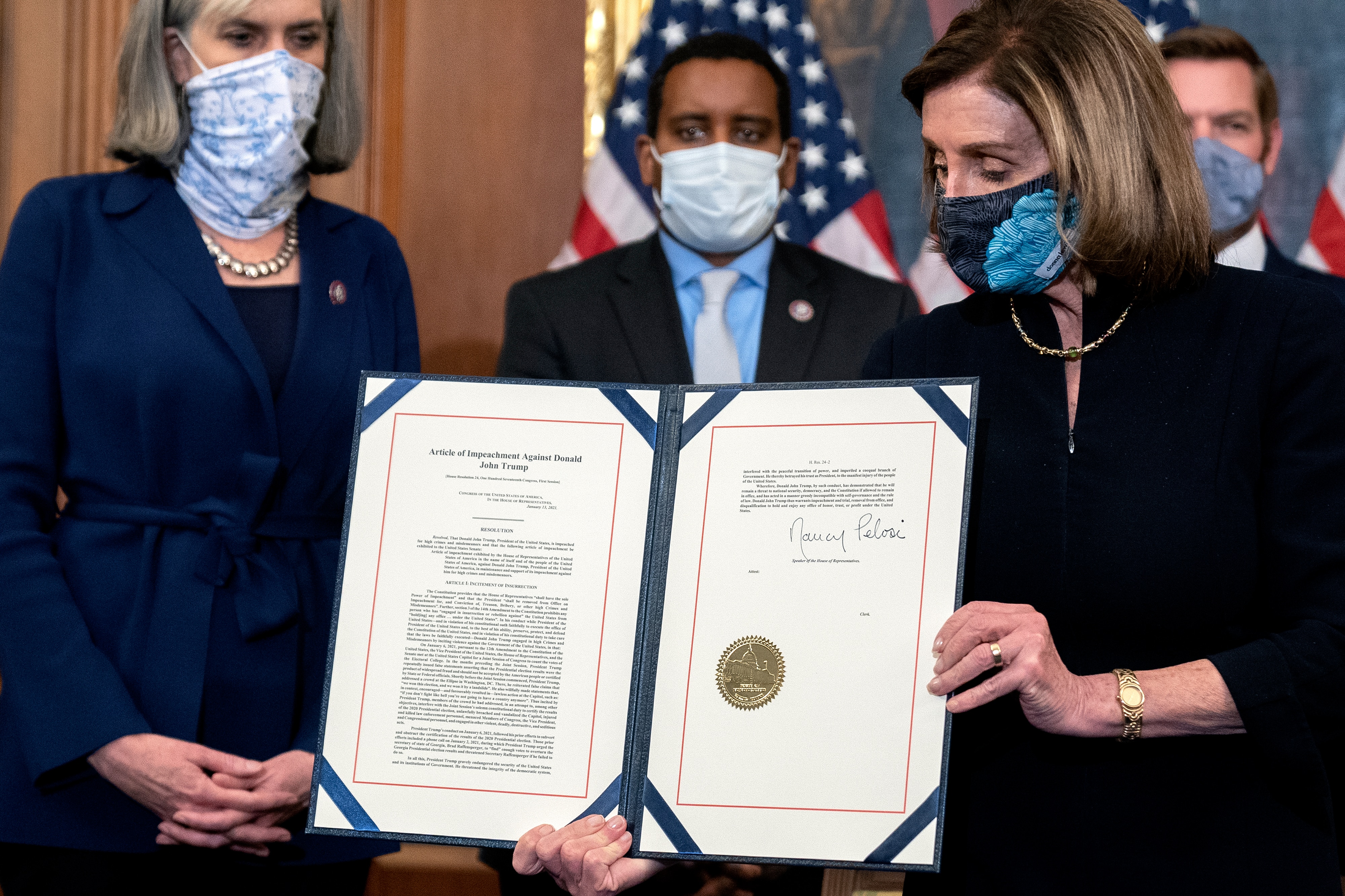 Nancy Pelosi displays a signed article of impeachment against then-President Donald Trump at the US Capitol on January 13, 2021.