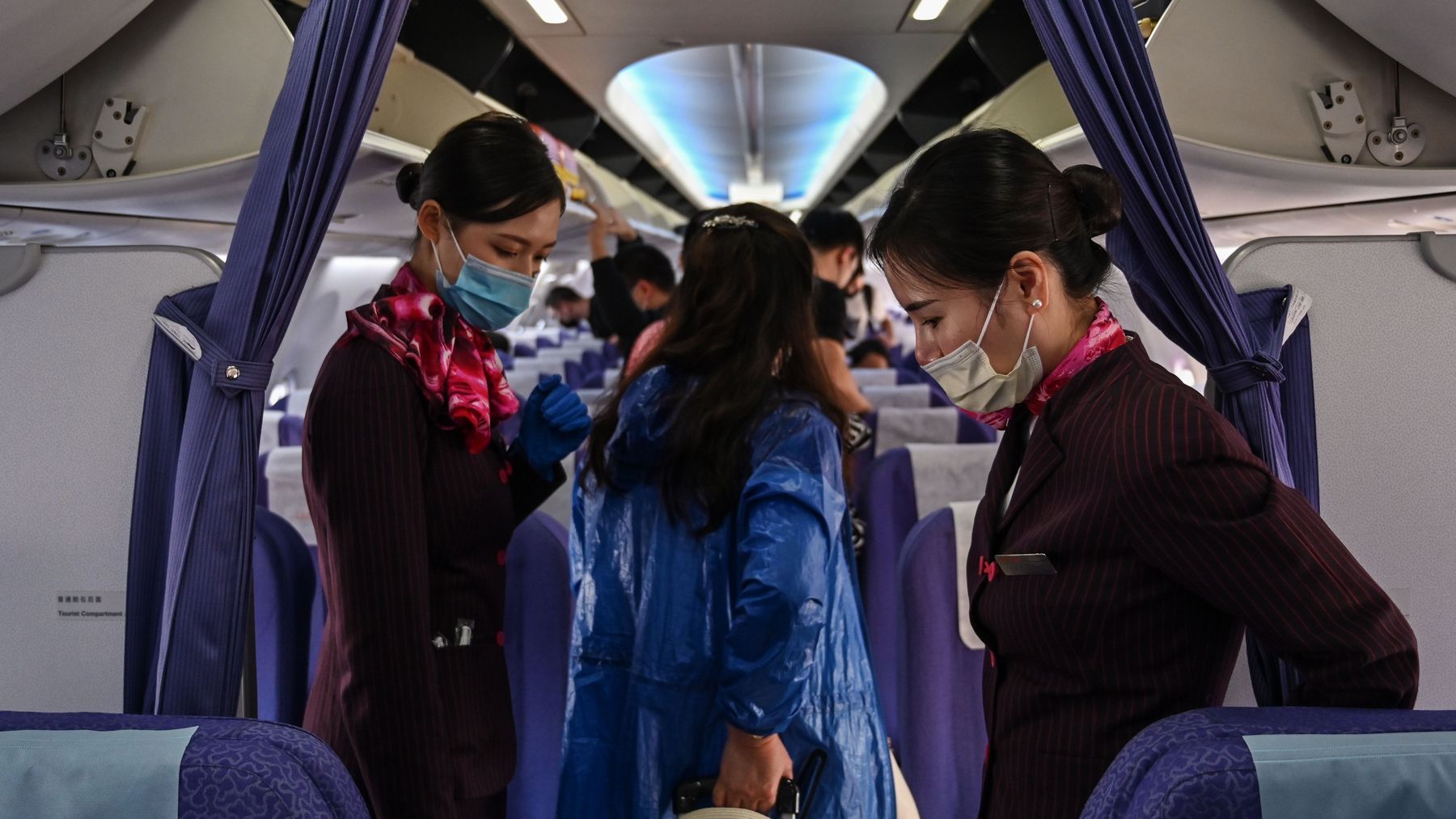 Hostesses with protective masks welcome passengers board their flight to Shanghai at Suvarnabhumi airport in Bangkok, on February 24, 2020. 