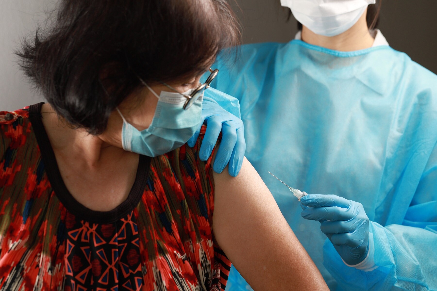 Syringe needle and vaccine in the hands of a nurse. Preparation of coronavirus vaccine for senior