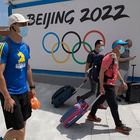 Visitors walk past by the Winter Olympics Beijing 2022 logo in Chongli, in northern China's Hebei Province.