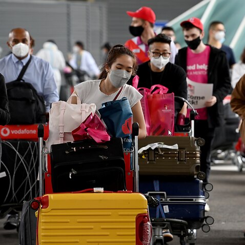 International students wear face masks as they arrive at Sydney Airport in Sydney.