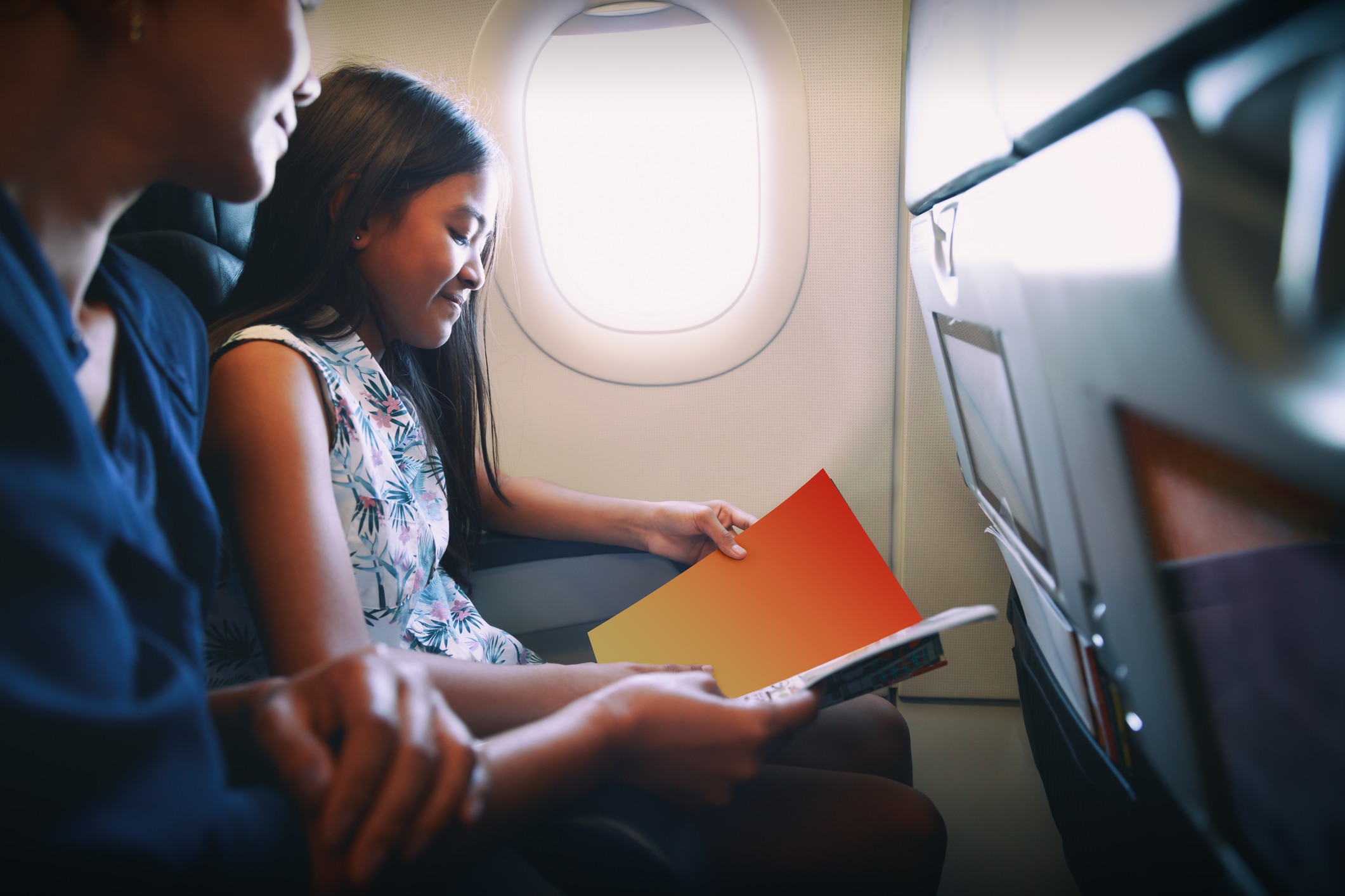 Mother with daughter sit on their place in airplane