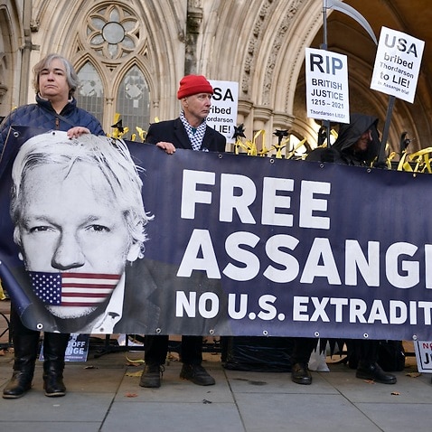 Supporters of Julian Assange urge his release outside of the Royal Courts of Justice in London.