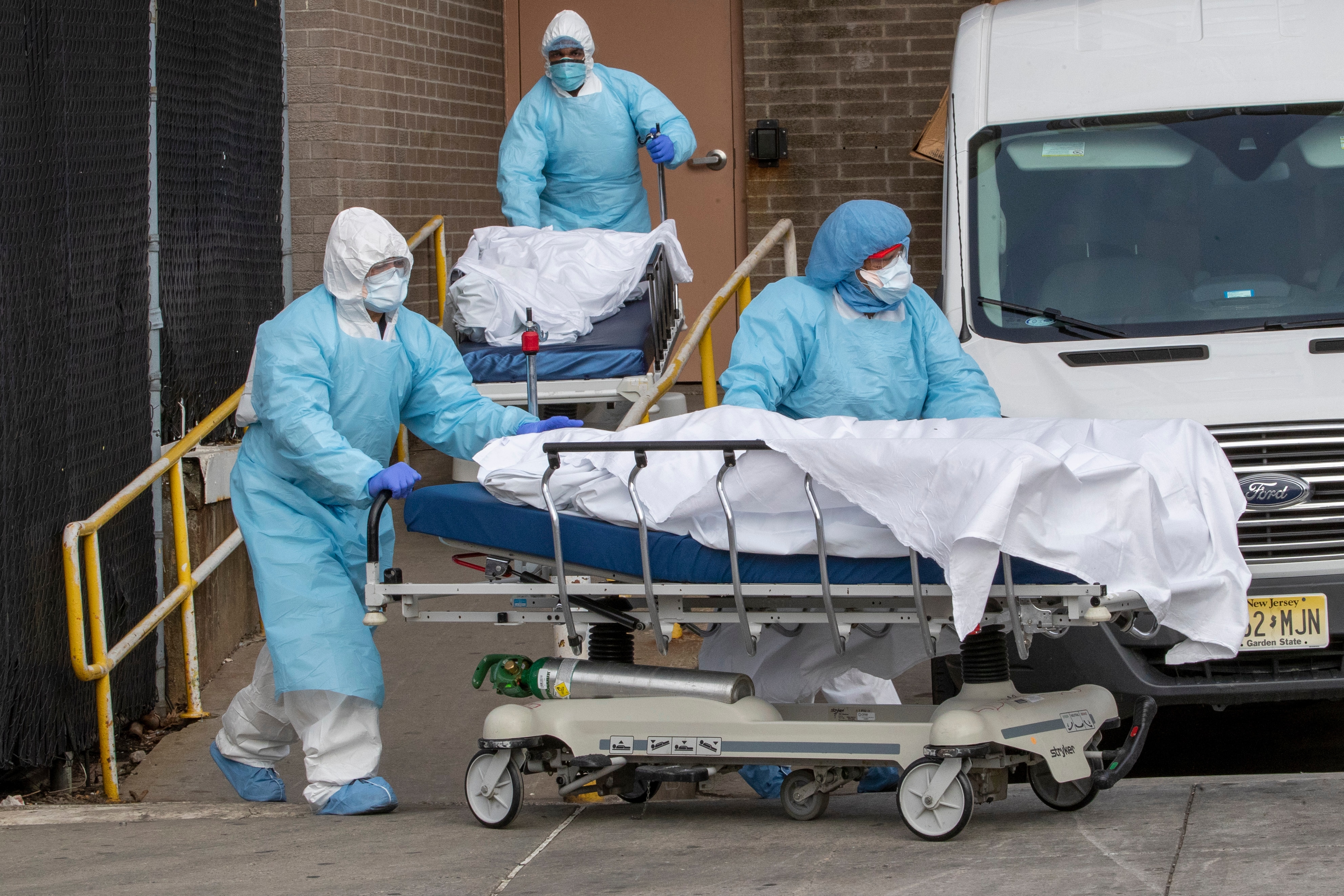 El personal médico que lleva equipo de protección personal retira los cuerpos en Nueva York.