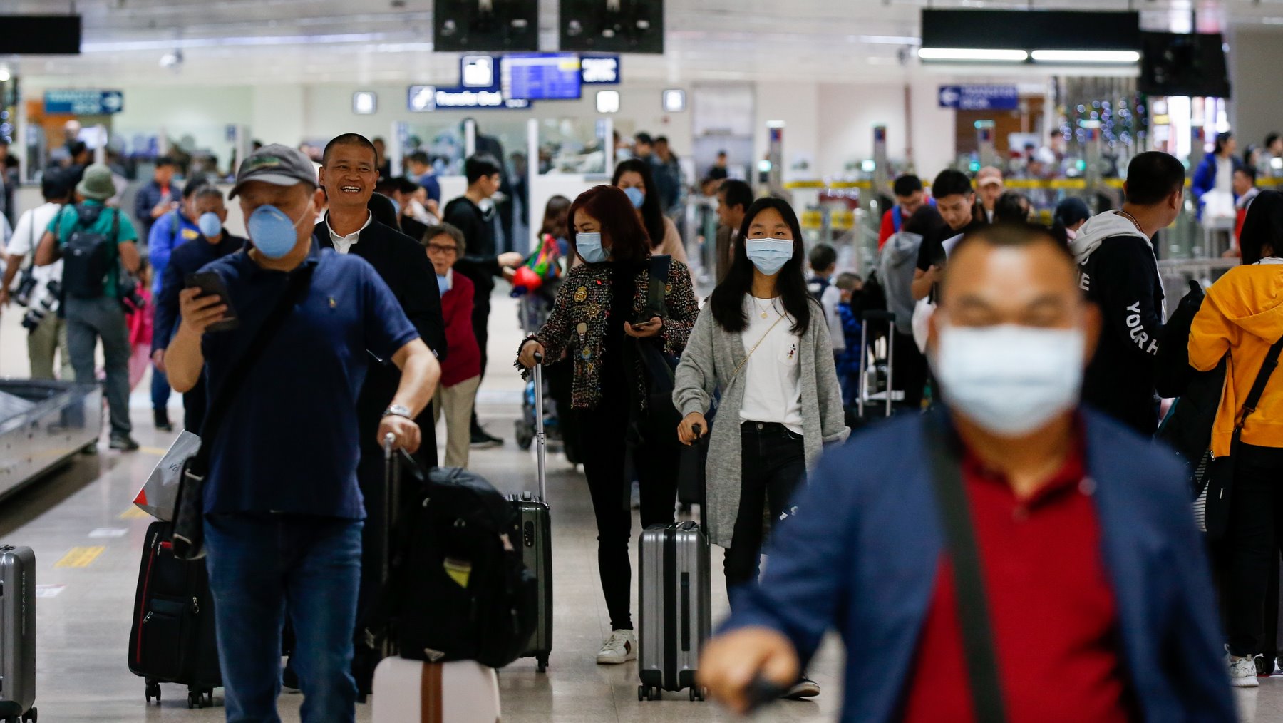 Passengers wearing face masks who arrived from Guangzhou, China prepare to exit the airport at Manila, Philippines, 22 January 2020. EPA/MARK R. CRISTINO