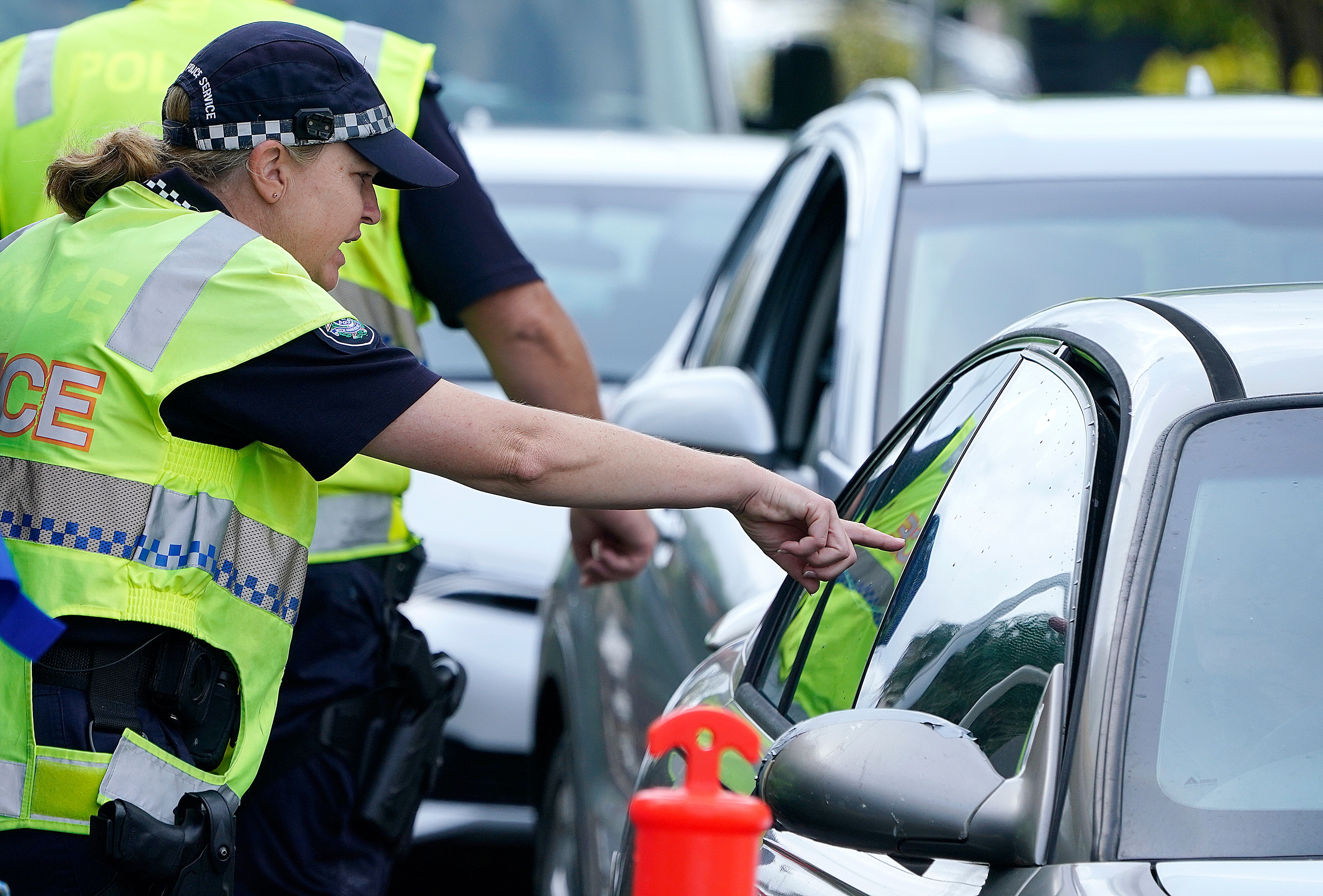 A police officer talks to drivers on the now-closed border of Queensland and New South Wales.