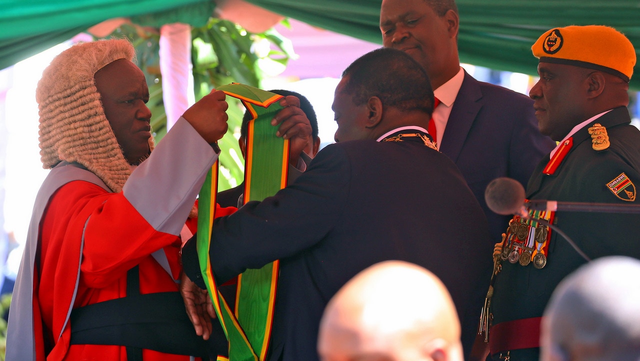 Emmerson Mnangagwa (3-R) receives his insignia after while being sworn-in by the Zimbabwe Chief Justice Luke Malaba.