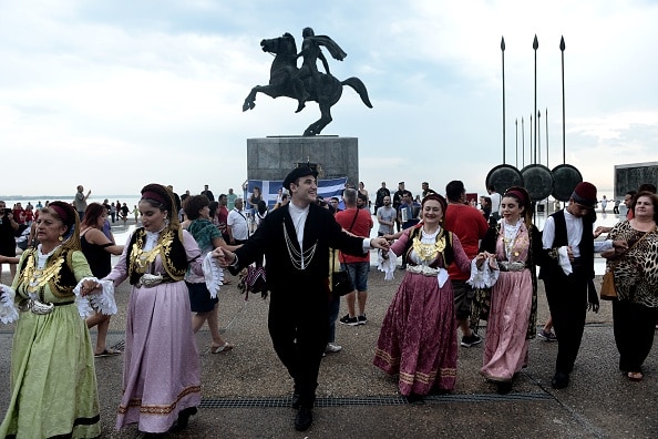 Macedonians wearing traditional costumes dance as they protest against the name deal between Greece and Macedonia.