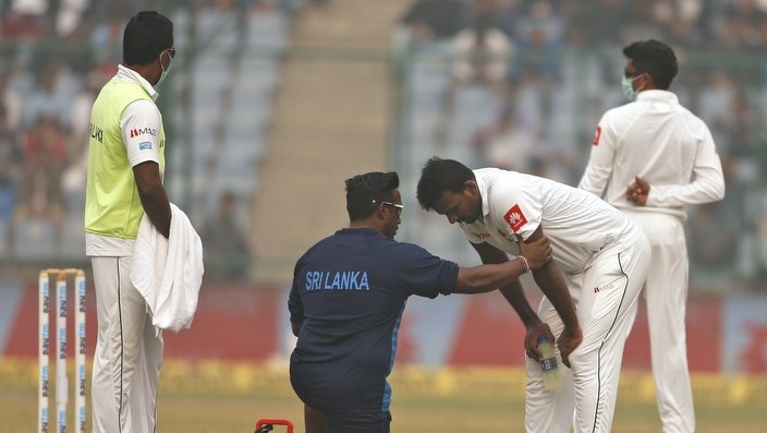A paramedic speaks to Sri Lanka's Lahiru Gamage after he complained of short of breath during the second day of a third test cricket match against India in New Delhi, India, Sunday, Dec. 3, 2017. (AP Photo/Altaf Qadri)