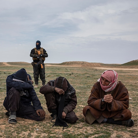 Men who fled the last village held by the Islamic State group wait to be questioned by coalition forces in the province of Deir el-Zour, Syria, on Feb. 7, 2019. (Ivor Prickett/The New York Times)