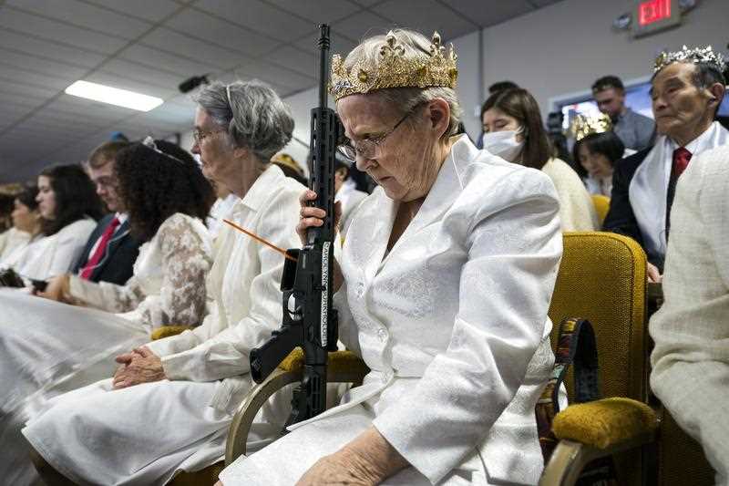 A parishioner with the Sanctuary Church holds onto her AR-15, which churchgoers were encouraged to bring to a blessing ceremony to rededicate their marriages 