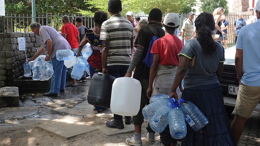 Residents queue for extra water at a natural spring in Cape Town.
