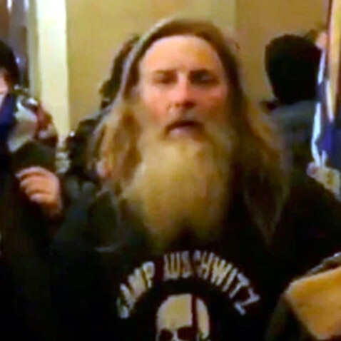 A man who was filmed wearing a 'Camp Auschwitz' shirt at the 6 January riots has been arrested.