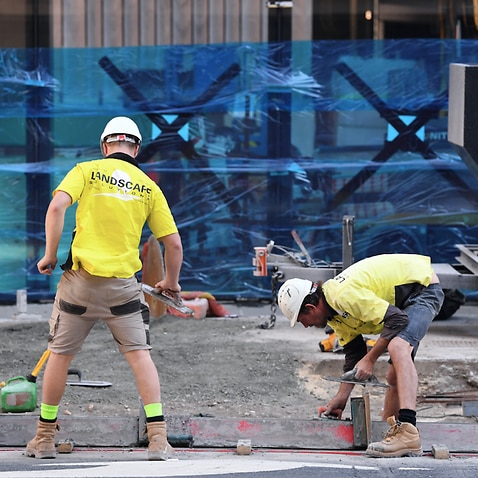 Workers are seen at a construction site in Brisbane.