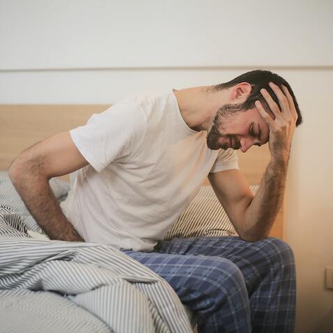 A man suffering headache in bed