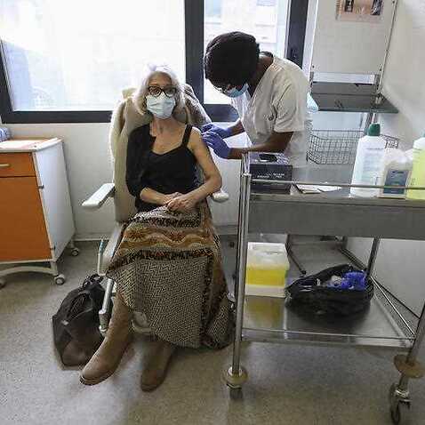 The Biontech/Pfizer vaccine is administered to a medical professional at a hospital in Paris. 