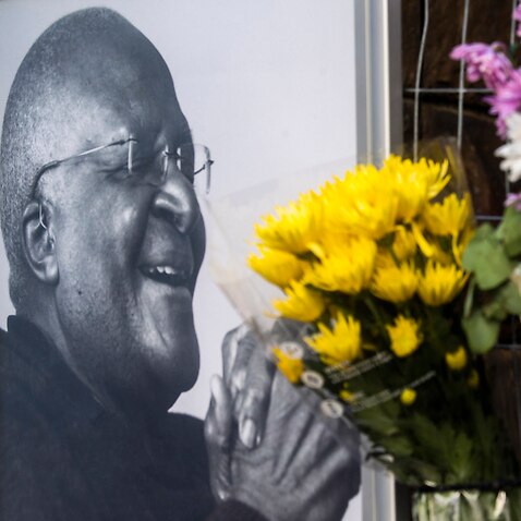 Flowers are posted alongside a photo of Anglican Archbishop Desmond Tutu at the St. Georges Cathedral in Cape Town, South Africa, Sunday, Dec. 26, 2021