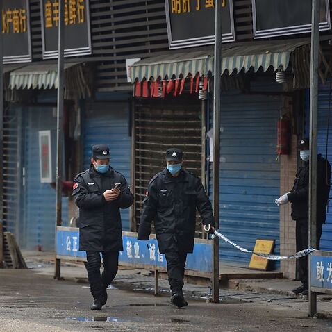 Security guards patrol outside the Huanan Seafood Wholesale Market where the coronavirus was detected in Wuhan