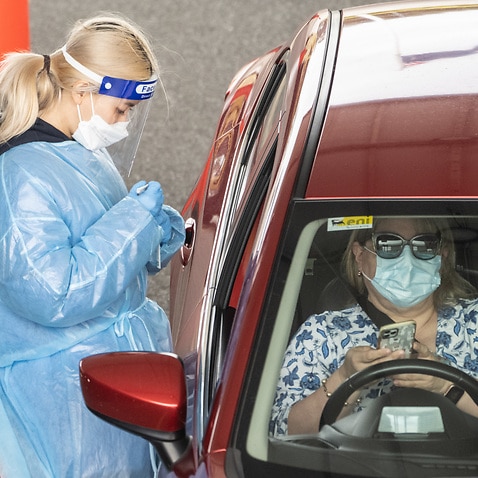 Healthcare workers adminstering COVID-19 tests at a drive through test centre in Sydney,