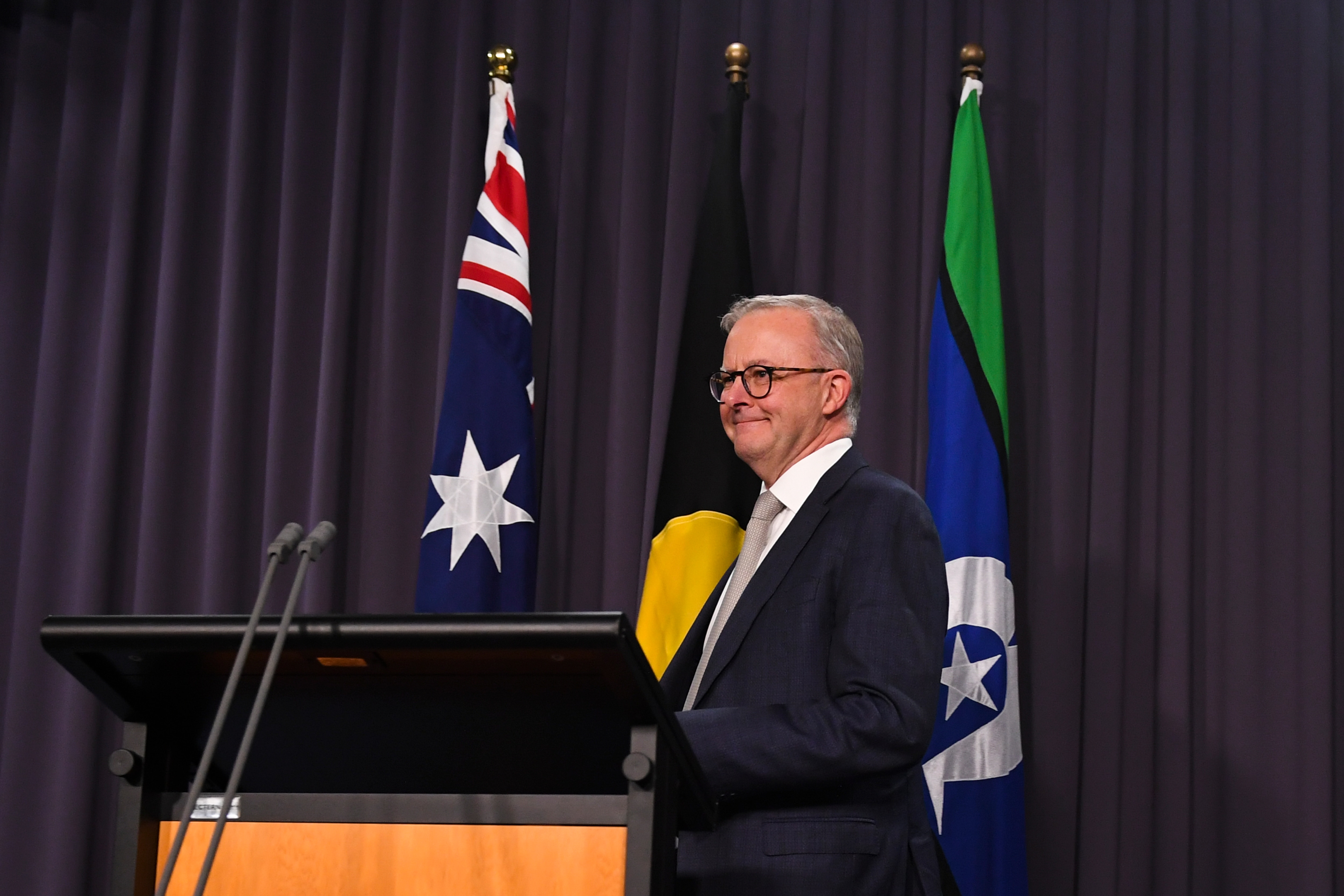 The Australian flag, the Aboriginal flag and the flag of the Torres Straits Islands are seen behind Australian Prime Minister Anthony Albanese during his press conference at Parliament House in Canberra, Monday, May 23, 2022. (AAP Image/Lukas Coch) NO ARC