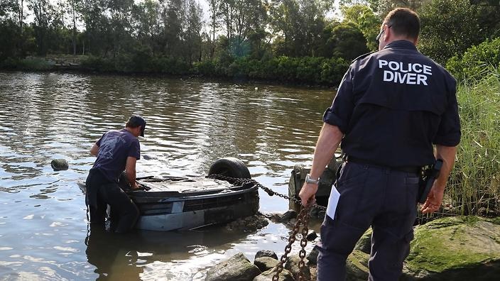 Police divers drag out a wrecked vehicle in the Georges Rivers, believed to have been used in an insurance fraud scheme