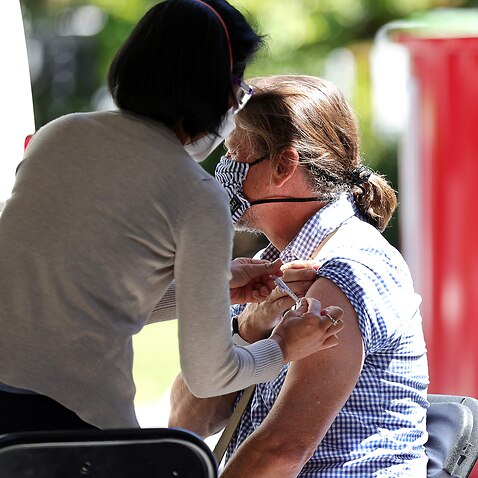 A woman is seen receiving a vaccination at a Cohealth pop-up vaccination clinic at the State Library Victoria, in Melbourne.