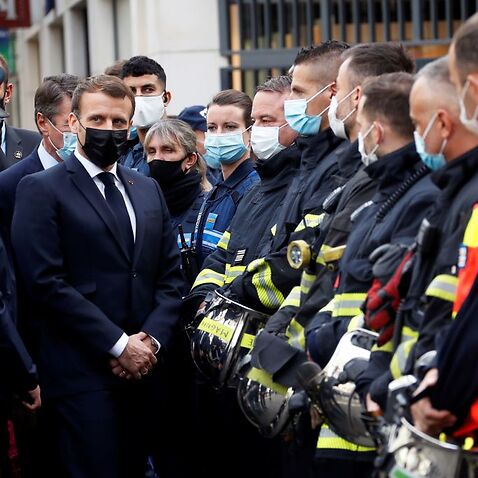 French President Emmanuel Macron (1st-L) visits the scene of a knife attack at the Basilica of Notre-Dame de Nice in Nice on 29 October. 