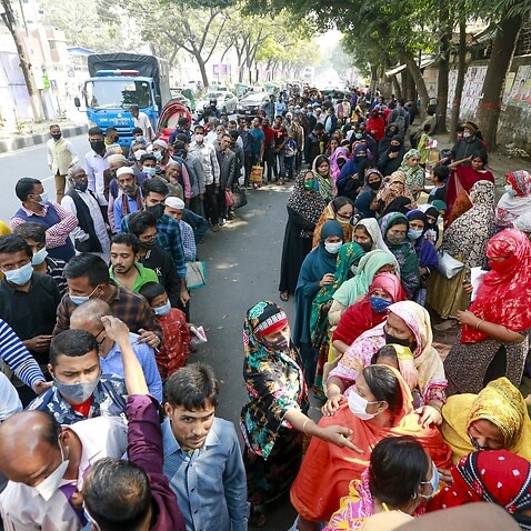 Bangladeshi people wait in a queue to buy essentials from Trading Corporation of Bangladesh. 16 February, 2022. 