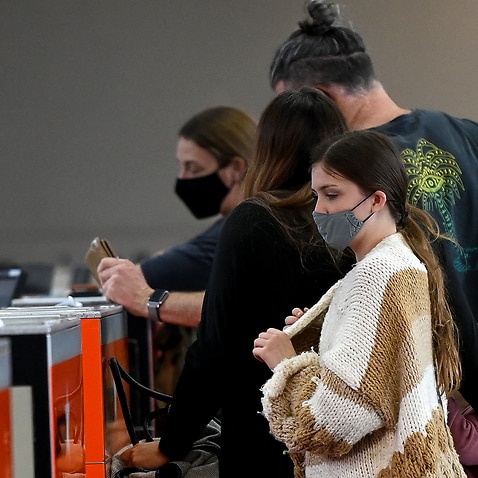 Passengers wear face masks as they line up in terminal at Sydney Domestic Airport 