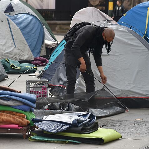 A homeless man packs up his tent in Sydney's Martin Place.