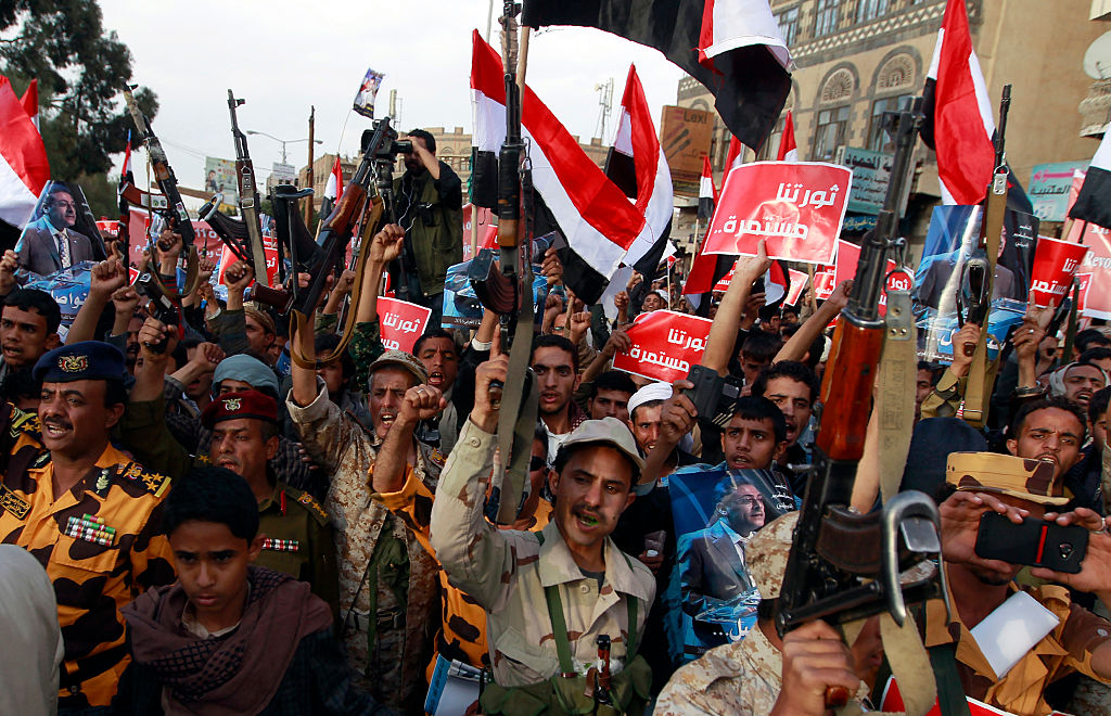 Os defensores do movimento Houthi agitam suas bandeiras nacionais e faixas em Ã¡rabe: "nossa revoluÃ§Ã£o continua".