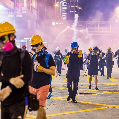 Demonstrators flee from tear gas during the protests against the extradition bill in Hong Kong.