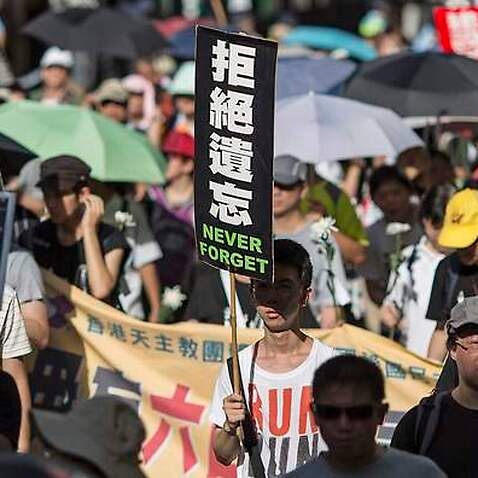 Protesters hold placards during a march for democracy in China, in Hong Kong, 01 June 2014. 