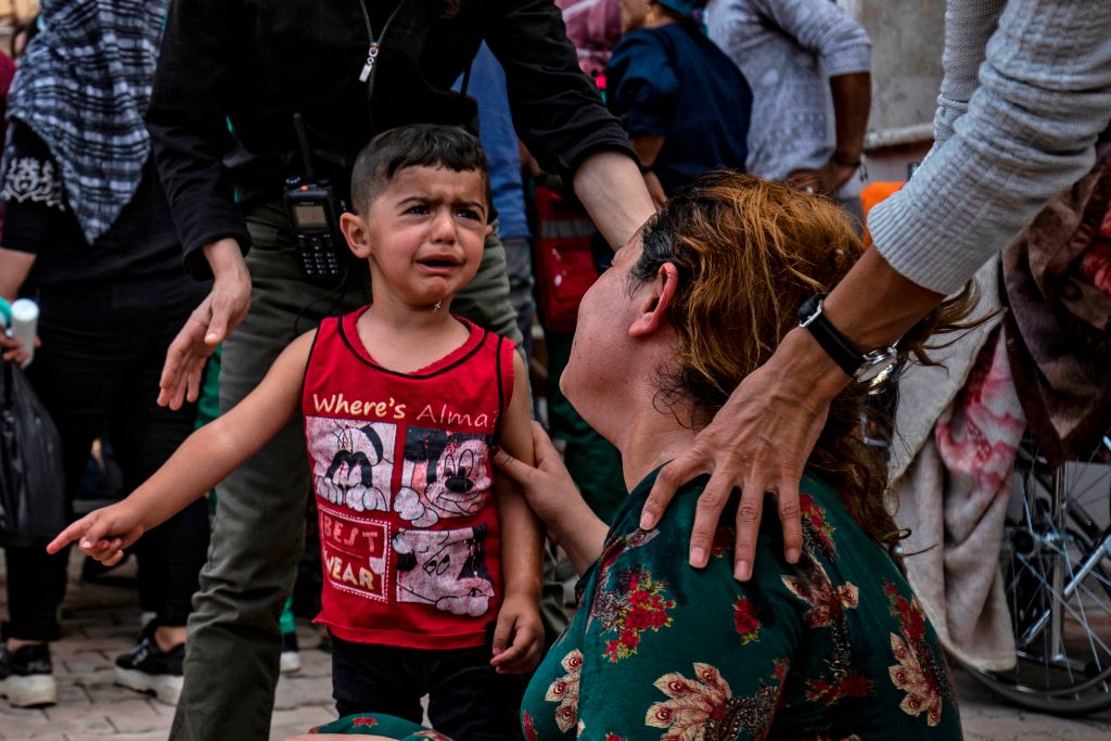 A woman and a child react to the body of a man killed during Turkish shelling in northern Syria. A woman and a child react to the body of a man killed during Turkish shelling in northern Syria.