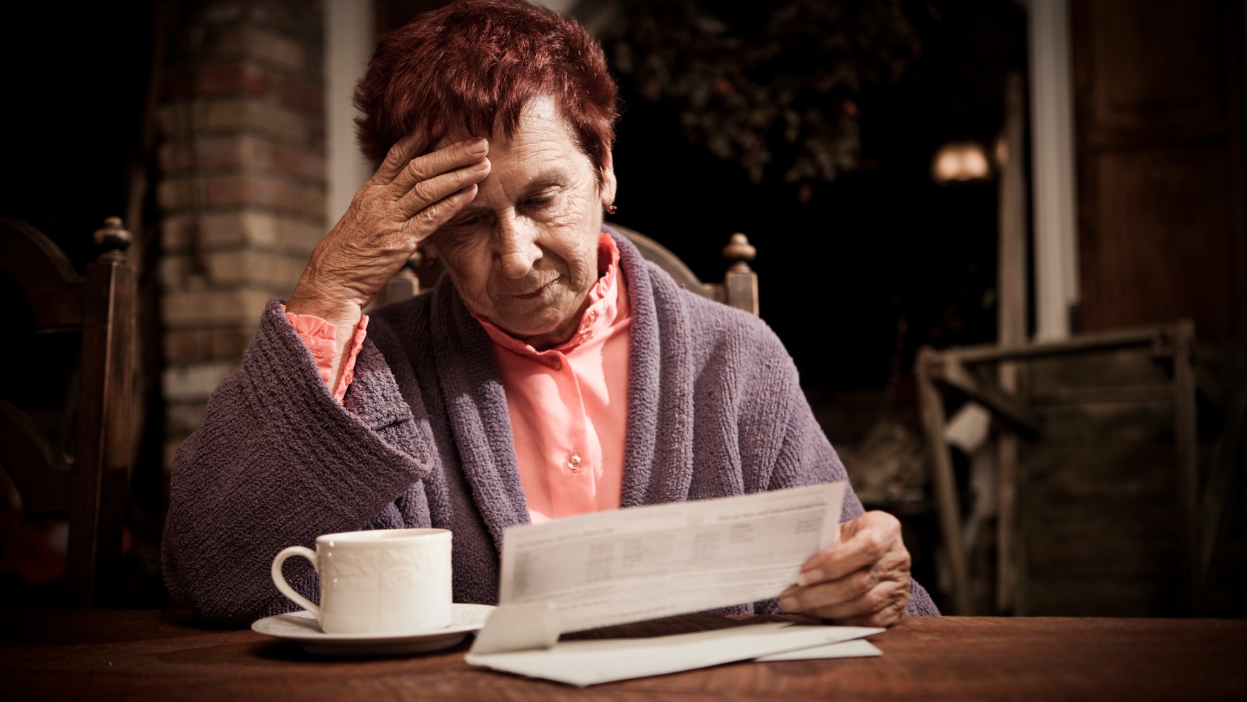 Distressed senior woman with bills