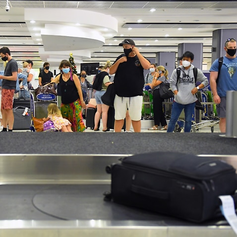 People are seen in the baggage collection area at Tullamarine Airport in Melbourne, January 8, 2021.