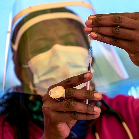 A health worker prepares a dose of the Pfizer coronavirus vaccine at the newly-opened mass vaccination program for the elderly at a drive-thru vaccination center outside Johannesburg, South Africa, 