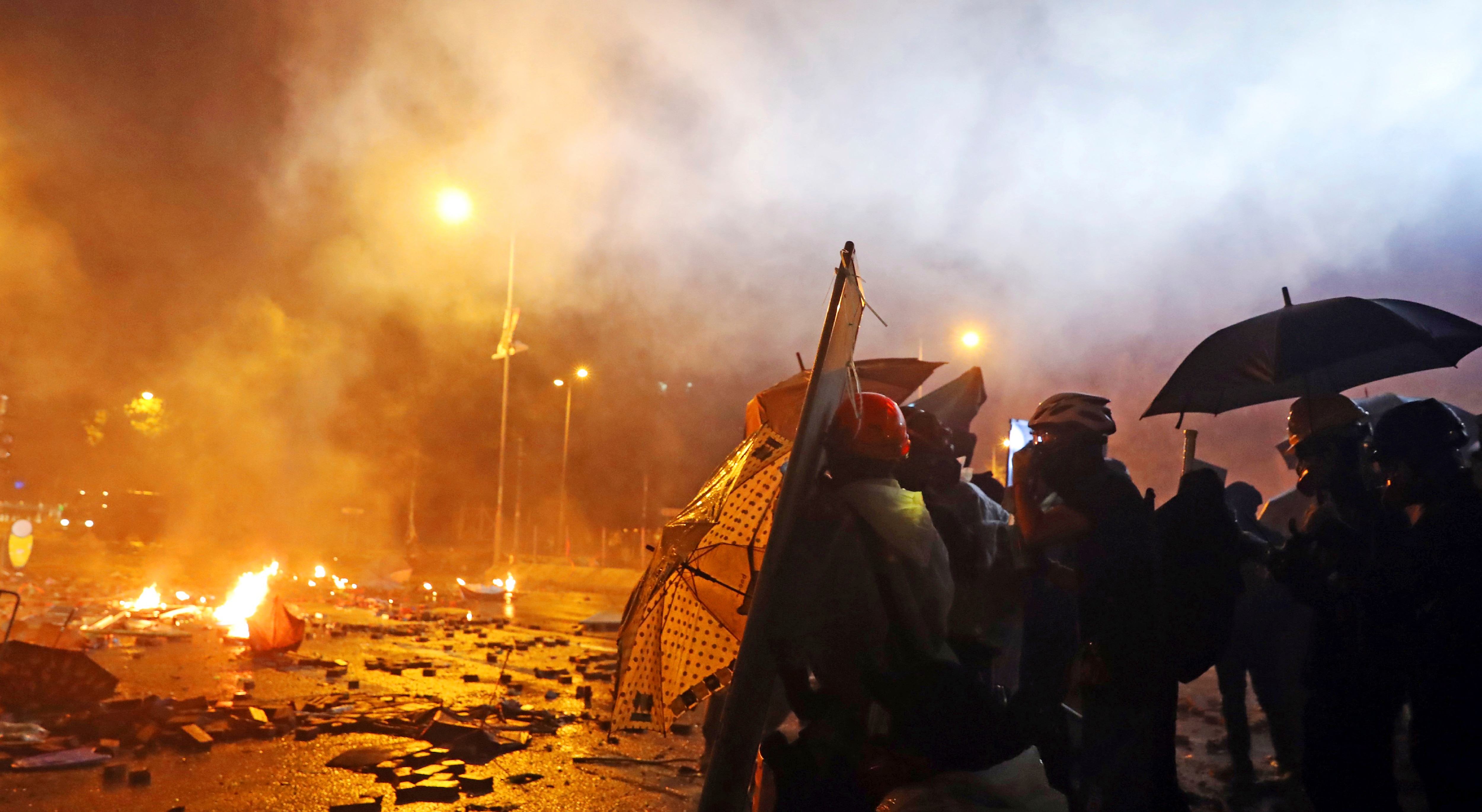 Protesters are thrown tear bombs by police officers on the street near Hong Kong Polytechnic University in Hong Kong on 17 November, 2019. Protesters are thrown tear bombs by police officers on the street near Hong Kong Polytechnic University in Hong Kong on 17 November, 2019.