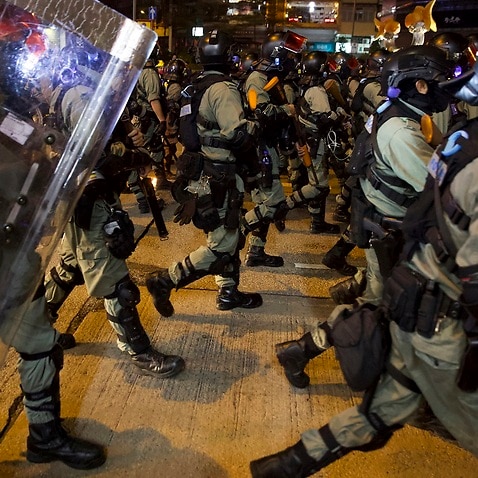 Riot police advance along a street in Hong Kong on Saturday.