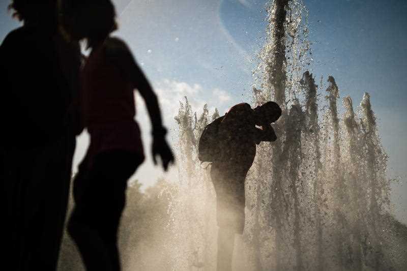 A man cools himself  in a fountain at Lustgarten park in Berlin, Germany.