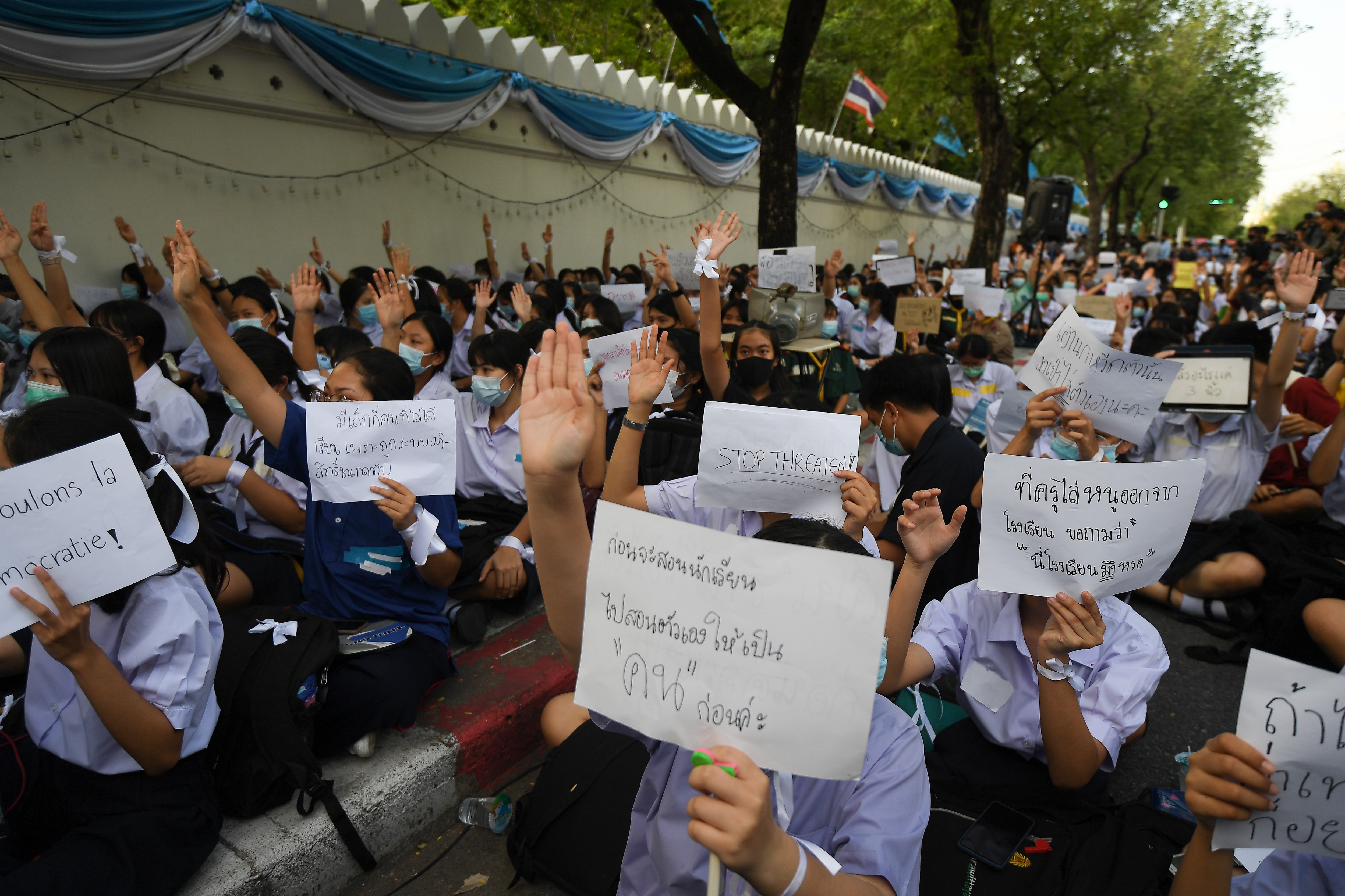 Thai high-school students protest with placards and white ribbons. 