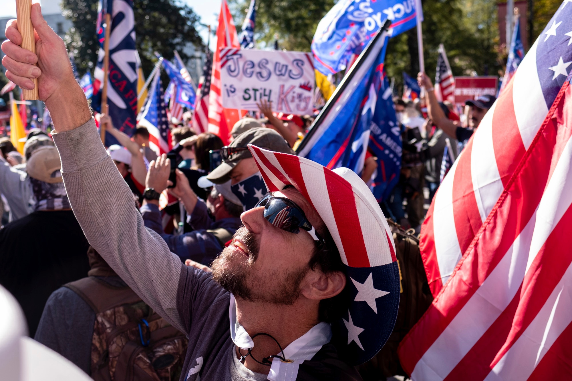 Rusty Albietz, of Blairsville, Ga., looks up at his flag while rallying with supporters of President Donald Trump outside of the Georgia State Capitol in Atlanta on Saturday, Nov. 21, 2020. (AP Photo/Ben Gray)