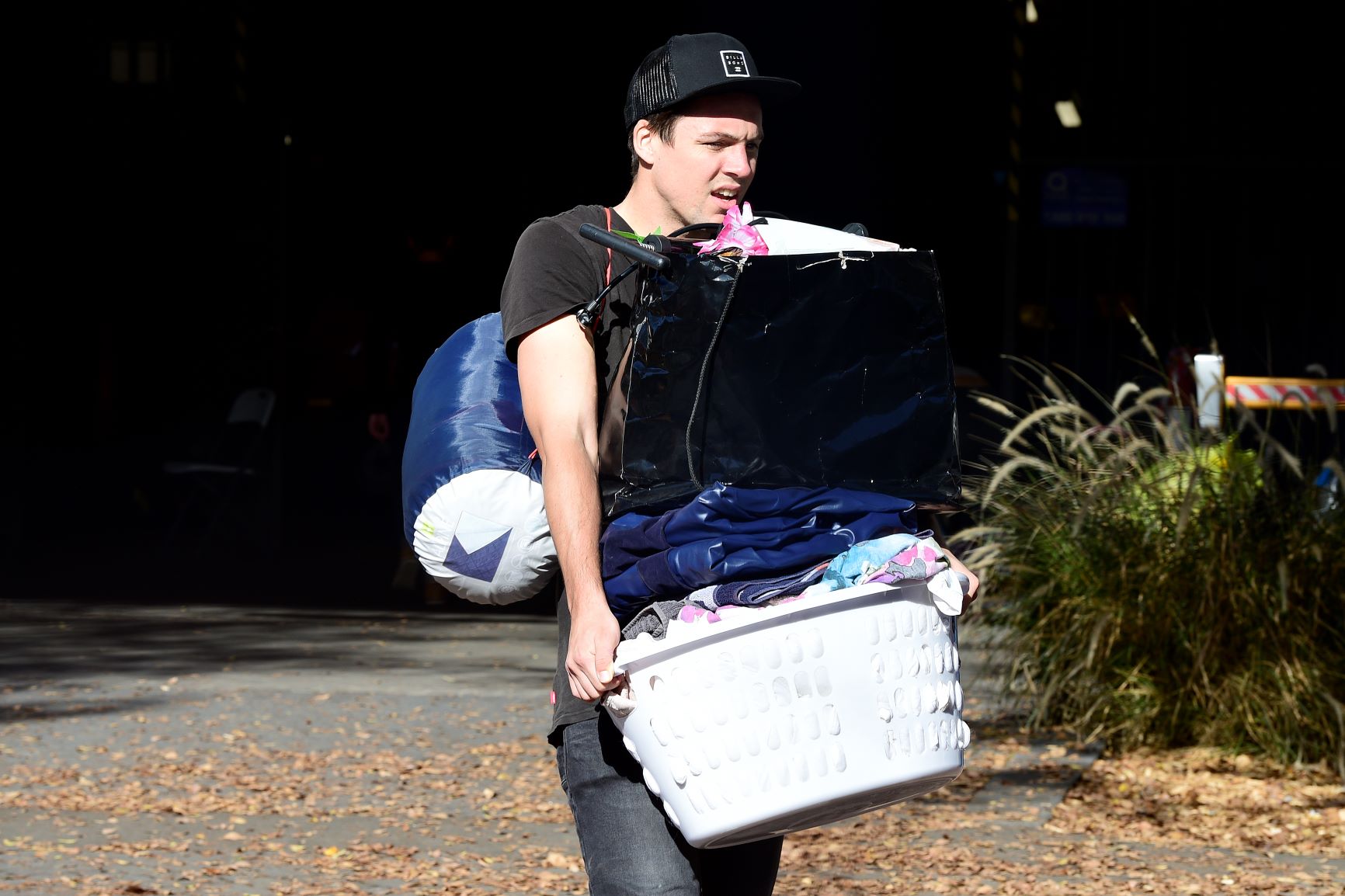 Residents are seen carrying their personal items out of the Mascot Towers in Mascot, Sydney, June 23, 2019.