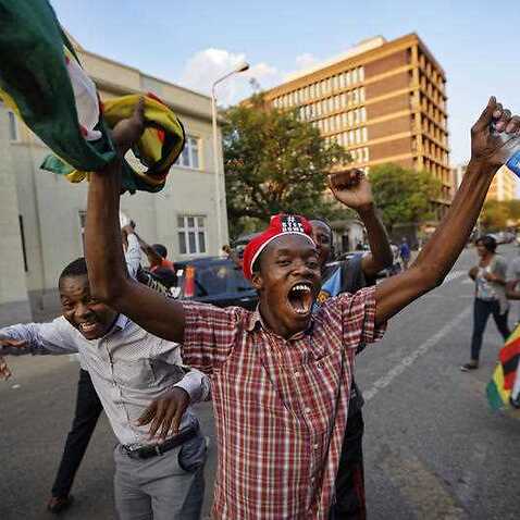 Zimbabweans celebrate outside the parliament building immediately after hearing the news that President Robert Mugabe had resigned, in downtown Harare, Zimbabwe Tuesday, Nov. 21, 2017.