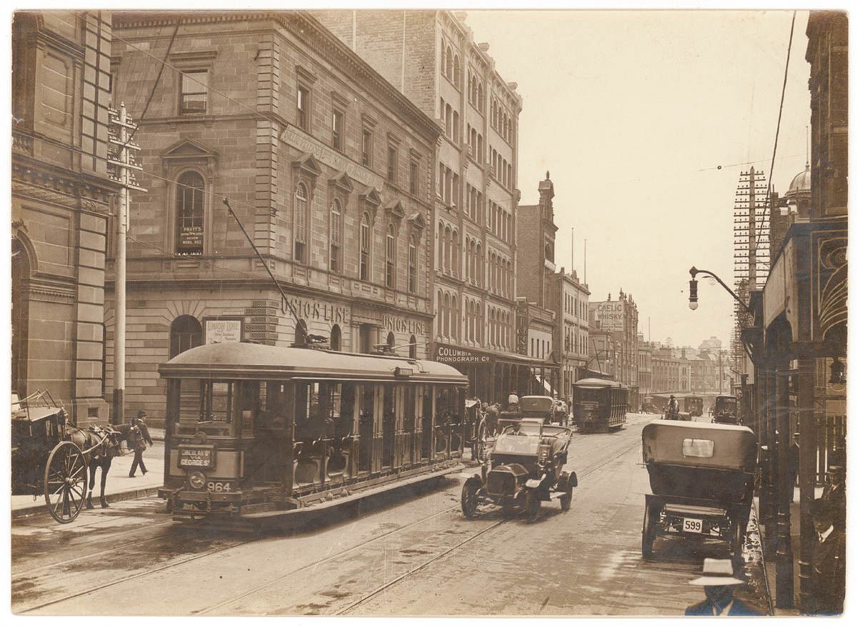 Looking north along George Street (with tram, T-model Ford and hansom cab) from Union Line Building (incorporating the Bjelke-Petersen School of Physical culture), corner Jamieson Street), n.d. by (5955844045)